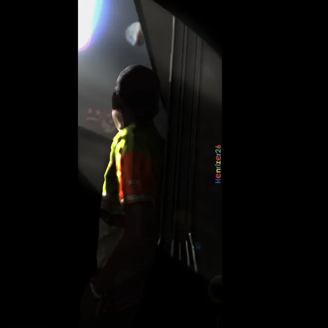 A figure silhouetted in a doorway against a bright projection.